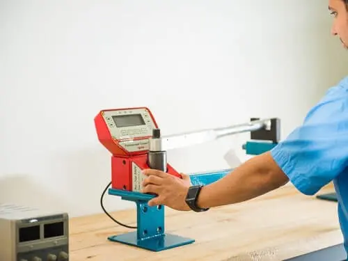 Ingeniero trabajando en calibración de torquimetro, con un sistema de calibración profesional